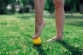 acupuncture foot massage with spiked rubber ball, women& x27;s feet doing yoga on the lawn in the early summer morning