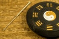 Acupuncture needle beside Chinese Taoism symbol
