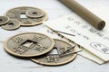 Acupuncture needles, Chinese coins and sheets of paper with characters on white wooden table, closeup Royalty Free Stock Photo