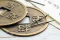 Acupuncture needles, Chinese coins and sheets of paper with characters on white wooden table, closeup Royalty Free Stock Photo