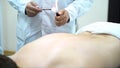 Acupuncture therapist placing a cup on the back of a male patient, ancient Chinese alternative medicine. Close up for a Royalty Free Stock Photo