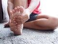 Acute foot pain of thai Asian women, Using hand massage on feet to relieve severe sore feet. Royalty Free Stock Photo