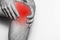 Acute pain in a knee joint, close-up. Monochrome image, on a white background. Pain area of red color Royalty Free Stock Photo