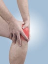 Acute pain in a man knee. Male holding hand to spot of knee-ach Royalty Free Stock Photo