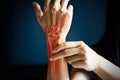 Acute pain in a woman wrist, colored in red on dark blue background. Health issues problems Royalty Free Stock Photo