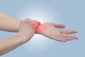 Acute pain in a woman wrist. Female holding hand to spot of wrist pain..Concept photo with Color Enhanced blue skin with read Royalty Free Stock Photo