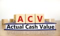 ACV actual cash value symbol. Concept words ACV actual cash value on wooden cubes on book on a beautiful wooden table, white