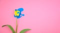 Acylic color blue dripping on yellow tulip flower flat lay on clear pink background.