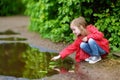 Ad girl playing in a puddle on rainy summer day Royalty Free Stock Photo