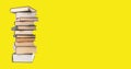 Ad school banner with stack of classics books, literature pile on yellow background with copy space Royalty Free Stock Photo