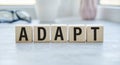 adapt text written on cubes wooden. on the background of a notebook Royalty Free Stock Photo