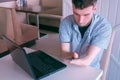 Disabled man with amputated stump hands typing message on mobile phone in cafe.