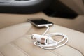 Adapter with connected charging cable and mobile phone in car, closeup Royalty Free Stock Photo