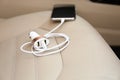 Adapter with connected charging cable and mobile phone in car, closeup Royalty Free Stock Photo