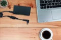 Adapter power cord charger of laptop computer with black coffee in white cup and cactus on wooden floor Royalty Free Stock Photo