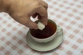 Add a cube of white sugar to a cup of tea