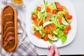 Add mustard to vegetable salad. vegetable salad with human hands. on a white plate. add spices Royalty Free Stock Photo