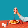 Food pop art photography. Female hands tasting spaghetti with meatballs on plaid tablecloth isolated on bright blue