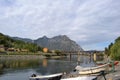 Adda river flowing from the lake Como, fishers and motorboats anchored at a shore.