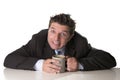 Addict businessman in suit and tie holding cup of coffee as maniac in caffeine addiction