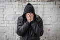 An addict experiencing a crisis of drug addiction after prolonged use of drugs and alcohol. A man covering his face with his hands Royalty Free Stock Photo