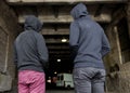 Addict men or criminals in hoodies on street