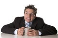 Addicted businessman in suit and tie holding cup of coffee as maniac in caffeine addiction