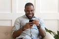 Addicted happy smiling african american guy using mobile phone. Royalty Free Stock Photo