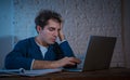 Addicted to internet young man hooked on the computer laptop late at night Royalty Free Stock Photo