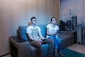 Addicted young man playing a video game sitting with his girlfriend