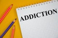 Addiction word written on white notepad and yellow background. word Royalty Free Stock Photo