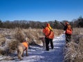 Two Hunters Wearing High Viz Clothing Wait For A Bird