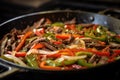 adding beef strips to sizzling pan for beef fajita Royalty Free Stock Photo