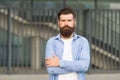 Adding care to his mustache. Serious guy wearing beard and mustache on urban background. Bearded man with stylish Royalty Free Stock Photo