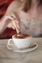 Adding creamer into a cup of cappuccino. Conceptual image shot