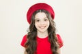 Adding an edge to the classic French look. Small child smiling with fashion look. Happy little girl wearing red beret