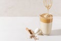 Adding foam in Dalgon coffee in a glass beaker on a light background