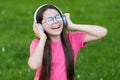 Adding happiness through singing. Happy singer sing song on green grass. Little girl enjoy singing in headphones