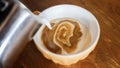 Adding milk foam to coffee to make a cup of cappuccino