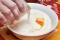 Adding milk to bowl with ingredients for dough