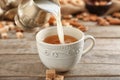 Adding milk to delicious tea on table Royalty Free Stock Photo