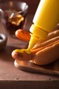 Adding mustard to grilled hot dog Royalty Free Stock Photo