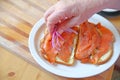 Adding onions to smoked salmon sandwich