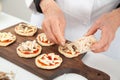 Adding toppings to the mini pizzas. Adding chicken. Delicious homemade mini pizzas preparation