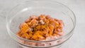 Adding turmeric to chopped chicken . Glass bowl with the chopped marinated chicken meat