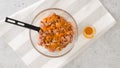 Adding turmeric to chopped chicken . Glass bowl with the chopped marinated chicken meat mixture inside