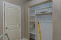 Adding a white melamine shelf to the interior of a clothing closet in which there are several empty shelves left to make