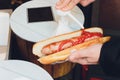 Adding yellow mustard to hot dog in hand. Royalty Free Stock Photo