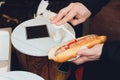 Adding yellow mustard to hot dog in hand. Royalty Free Stock Photo