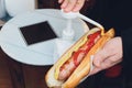 Adding yellow mustard to hot dog in hand. Royalty Free Stock Photo